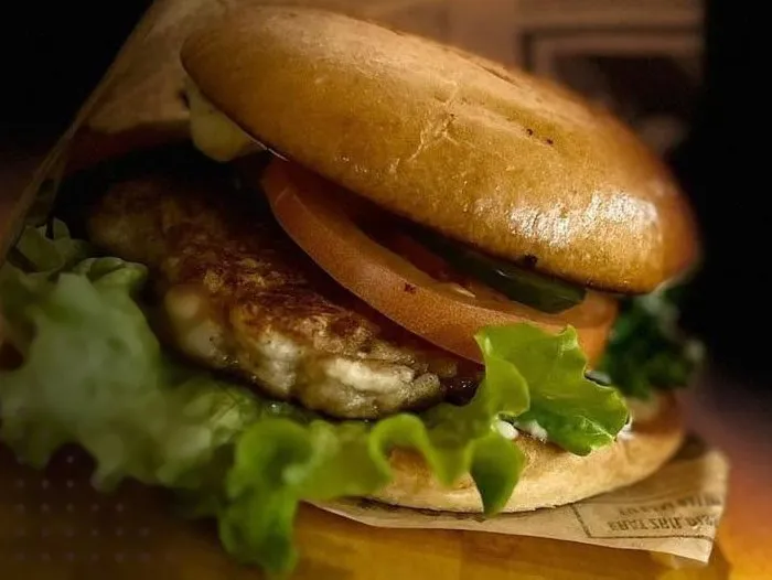 Burgers ar salātu lapu un tomātu, ietīts papīrā